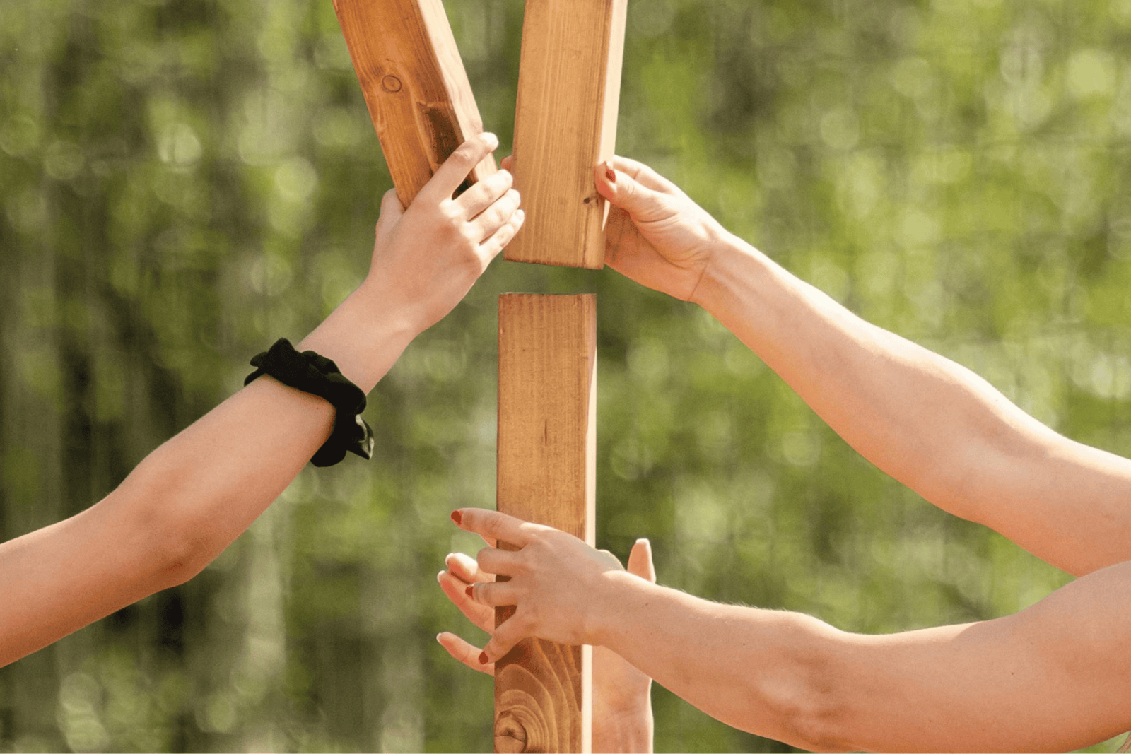 kädet kasaavat yhdessä palikoista tornia