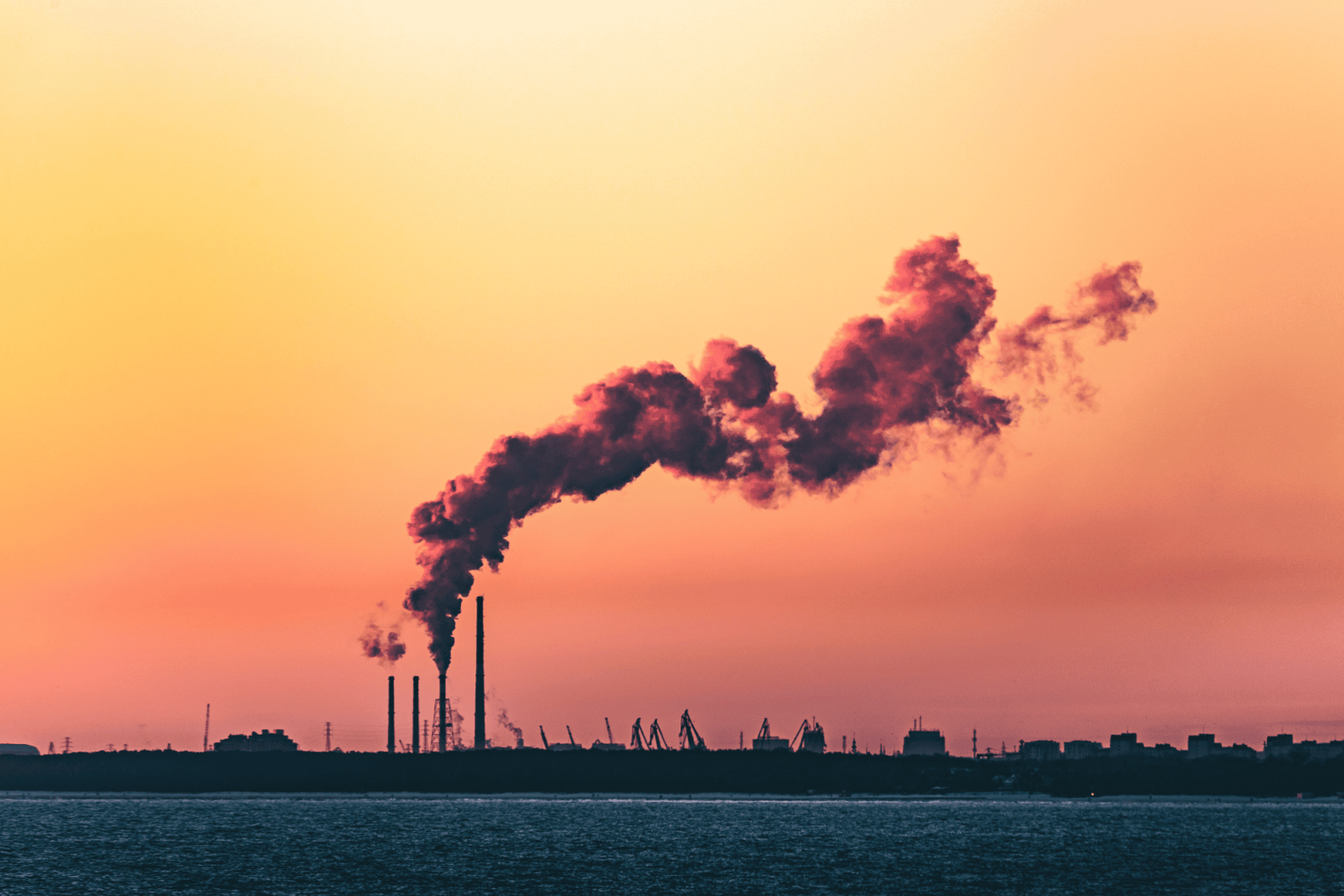 Kuvituskuva: teollisuusmaisema auringonlaskussa